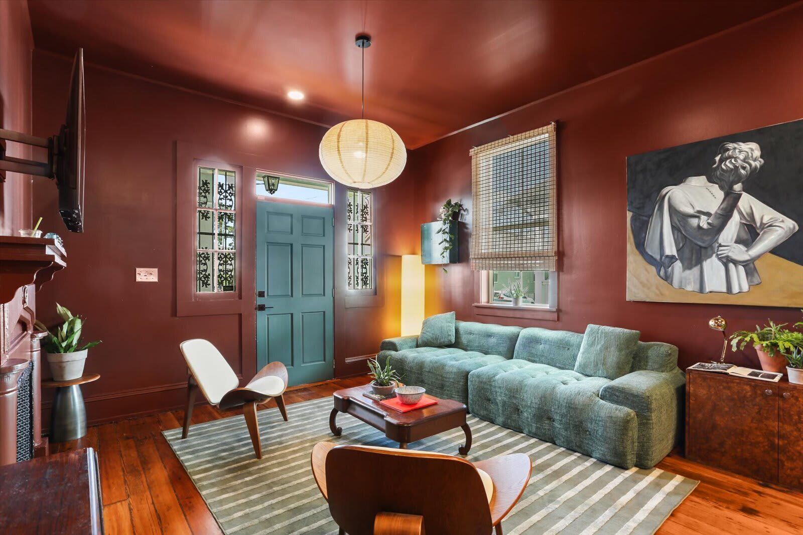 A living room with a sofa, chairs, a coffee table, and a painting on the wall.