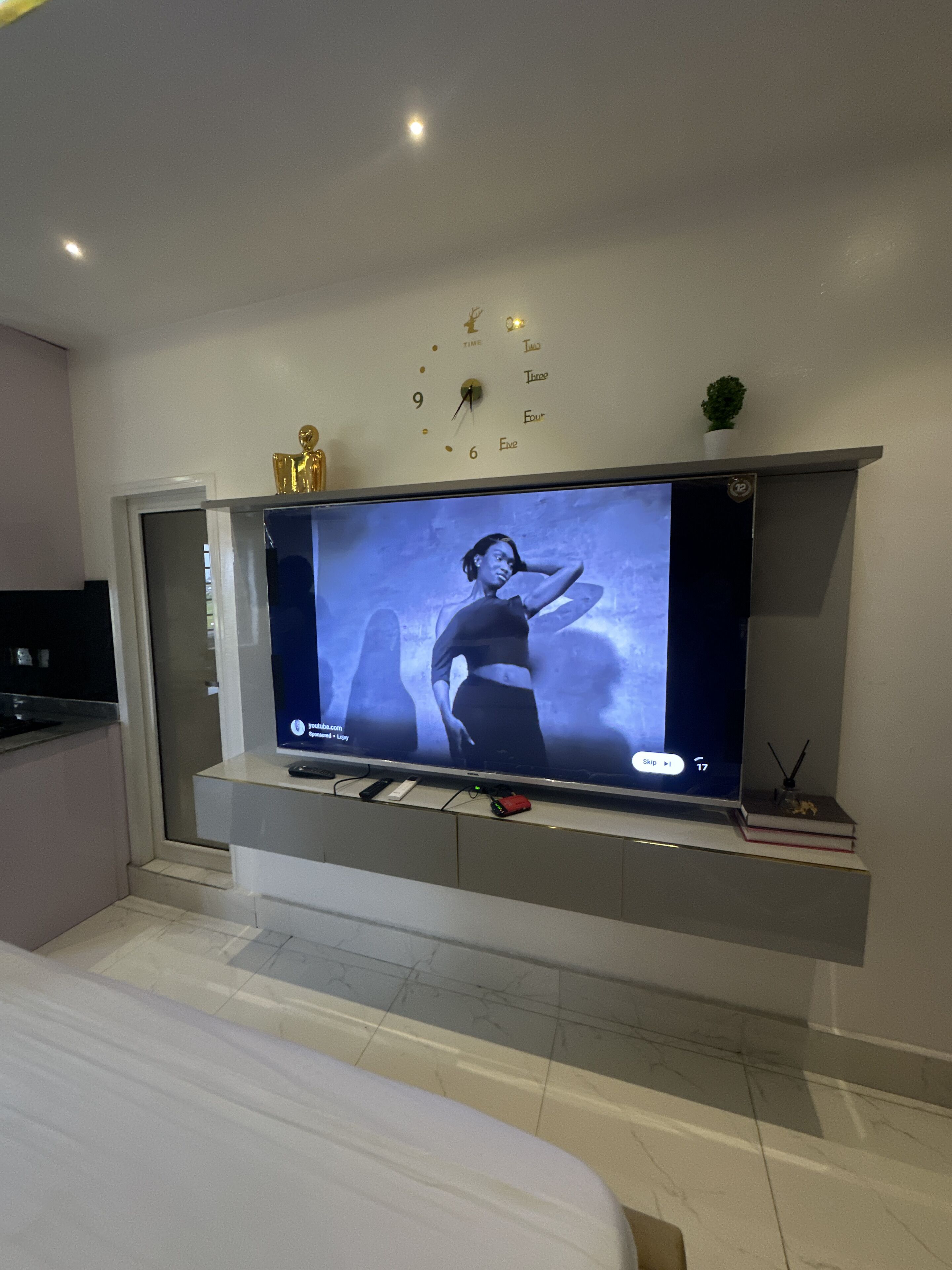 A modern living room with a flat-screen TV mounted on a wall above a sofa.