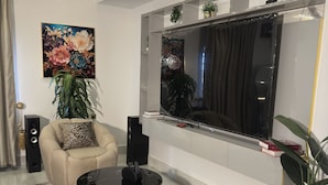 Una sala de estar moderna con un sofá, una mesa de centro y un televisor de pantalla plana grande.