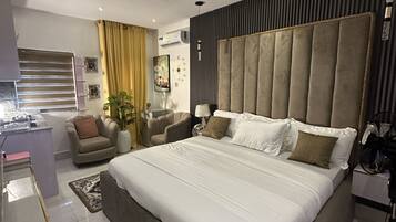 Une chambre à coucher moderne avec un grand lit, un bureau et une chaise.