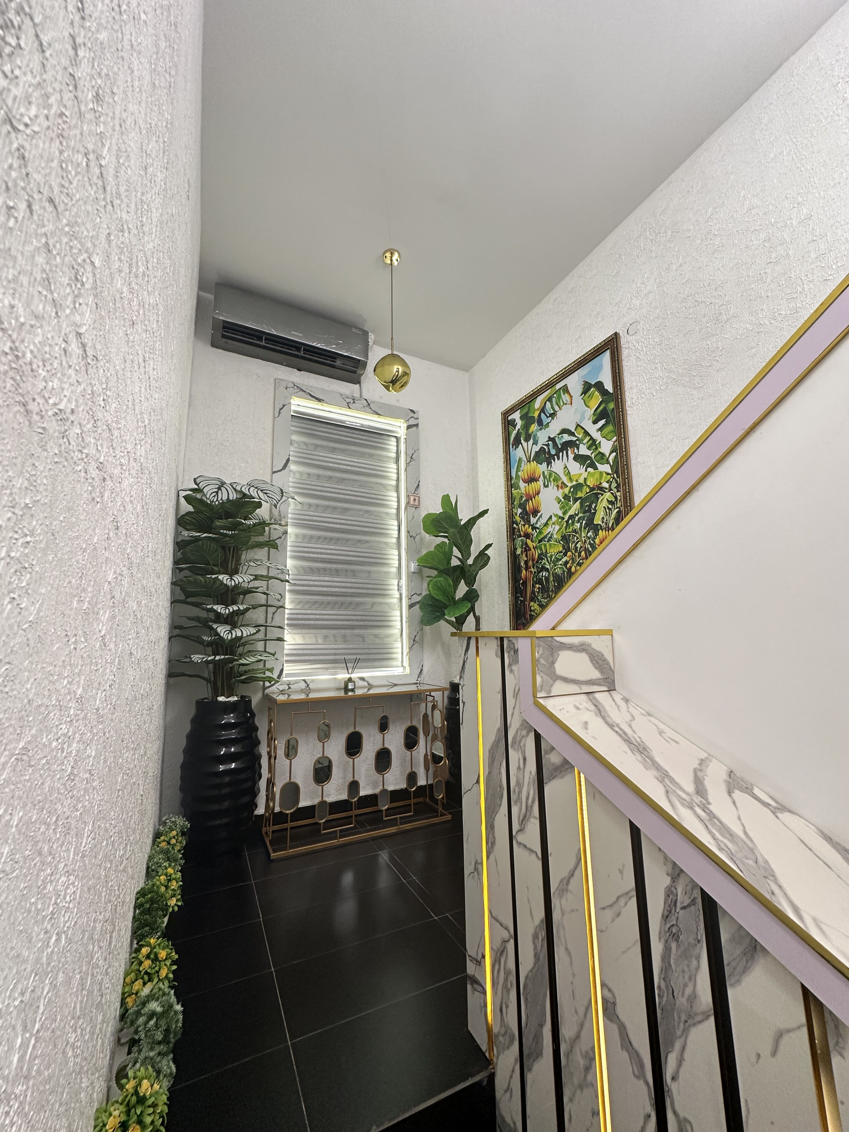 Uma escadaria com parede de mármore e chão de azulejos pretos.