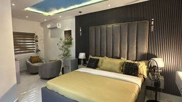 A modern bedroom with a large bed, a ceiling light fixture, and a bedside table with a lamp.