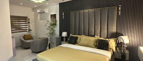 A modern bedroom with a large bed, a ceiling light fixture, and a bedside table with a lamp.