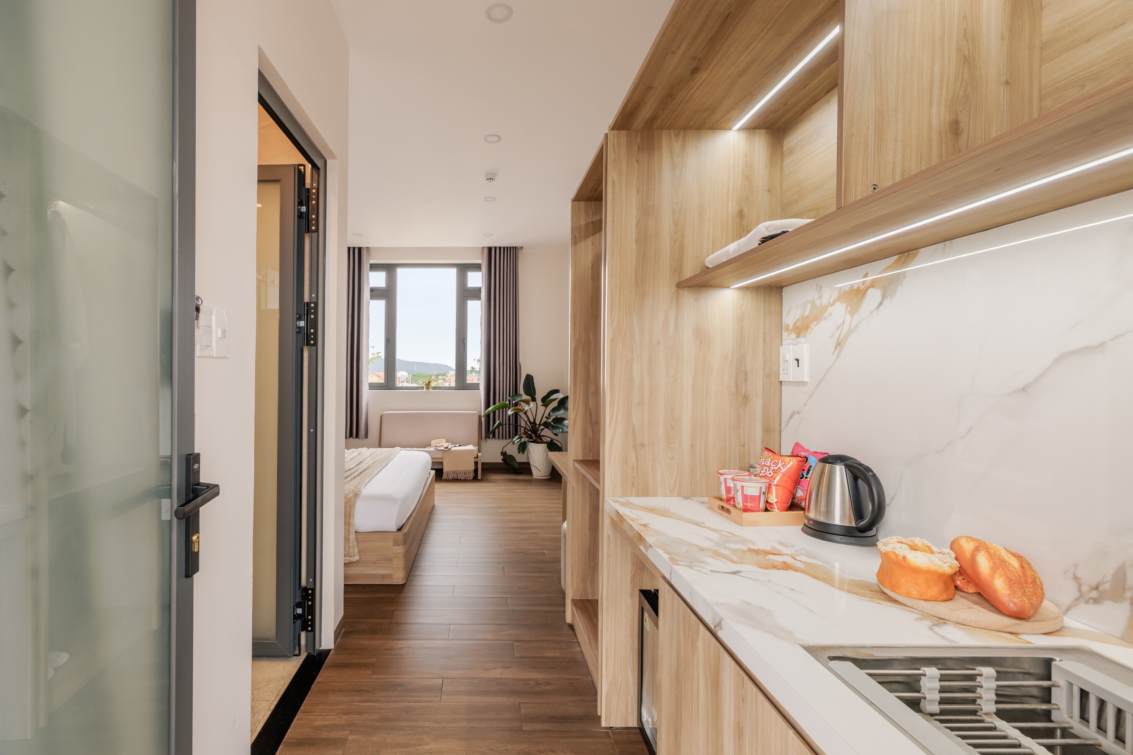 A modern kitchen with a marble countertop, a kettle, and a bread basket.