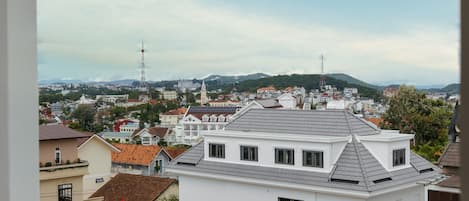 A residential area with a mix of modern and traditional architecture, including a prominent white building with a flat roof and a smaller building with a sloped roof.