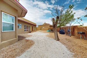A residential property with a gravel driveway, a covered patio area, and a barbecue grill. - Entire Desert Hacienda Estate Compound - Sleeps 12 in La Mesilla, New Mexico (Española)