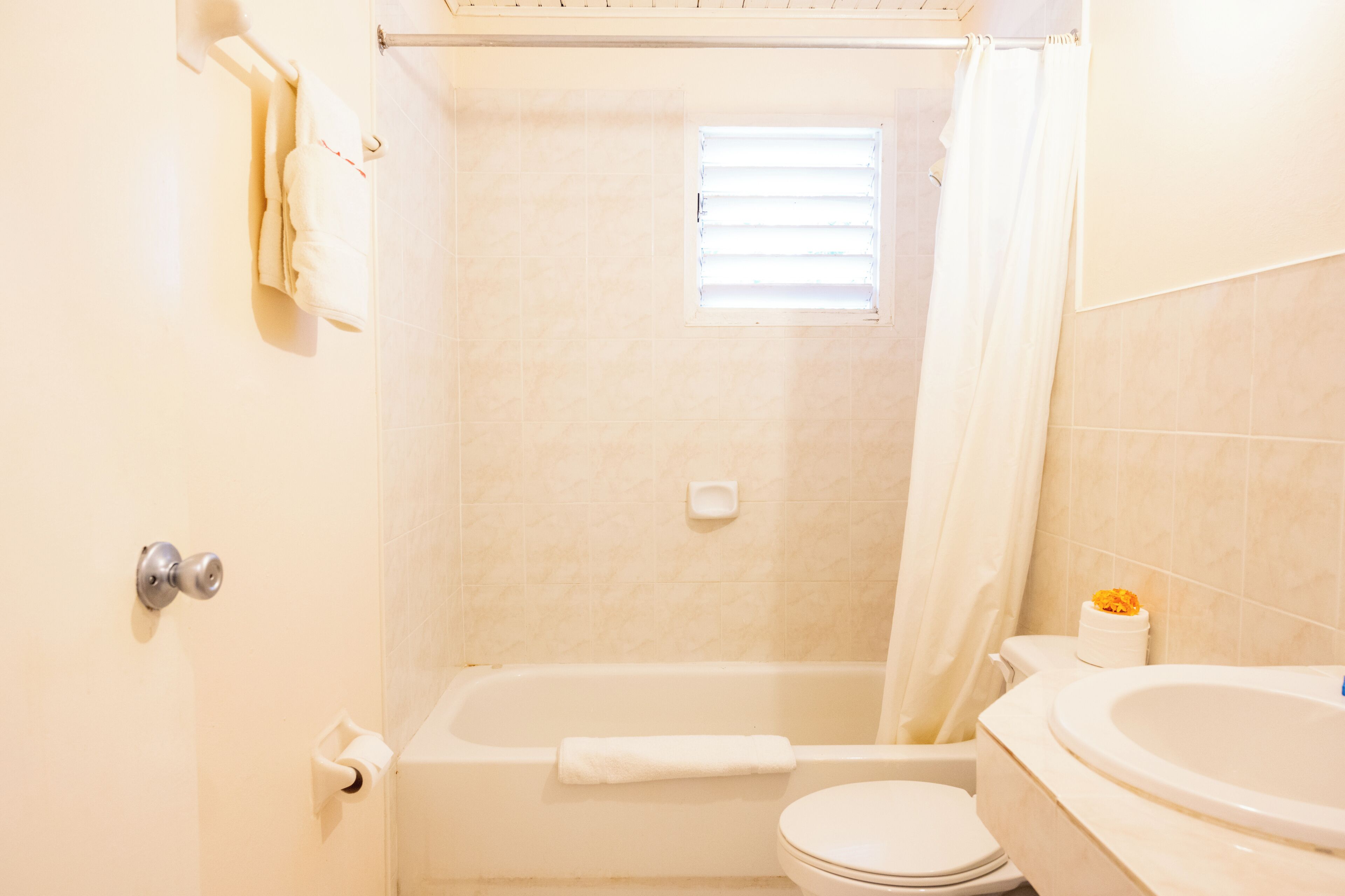 A bathroom with a bathtub, toilet, and a shower curtain.