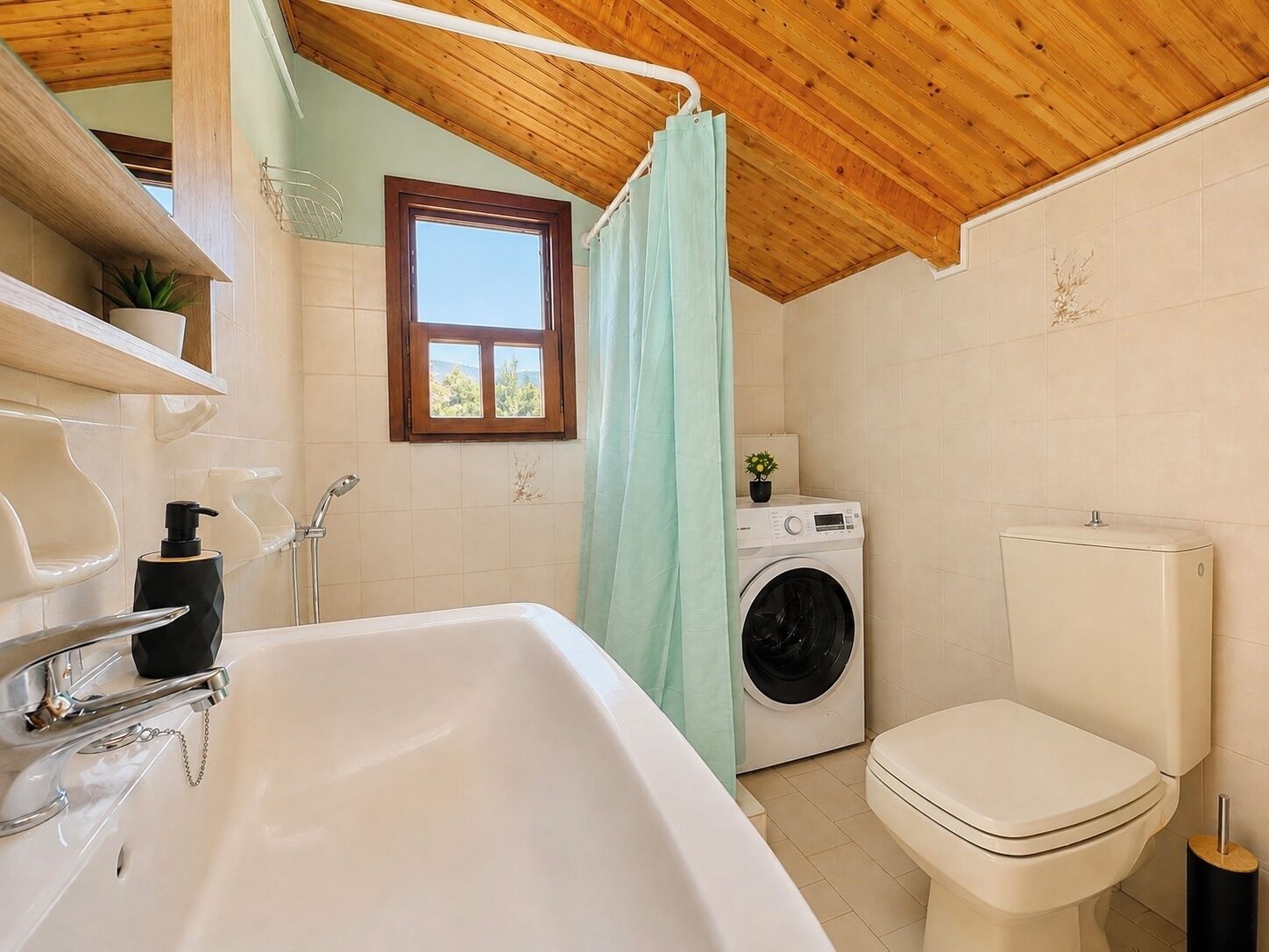 A bathroom with a sink, toilet, and washing machine.