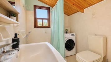A bathroom with a sink, toilet, and washing machine.