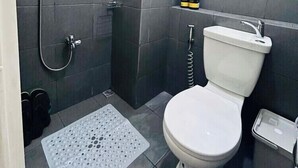 Ein kleines Badezimmer mit Toilette, Dusche und Waschbecken.