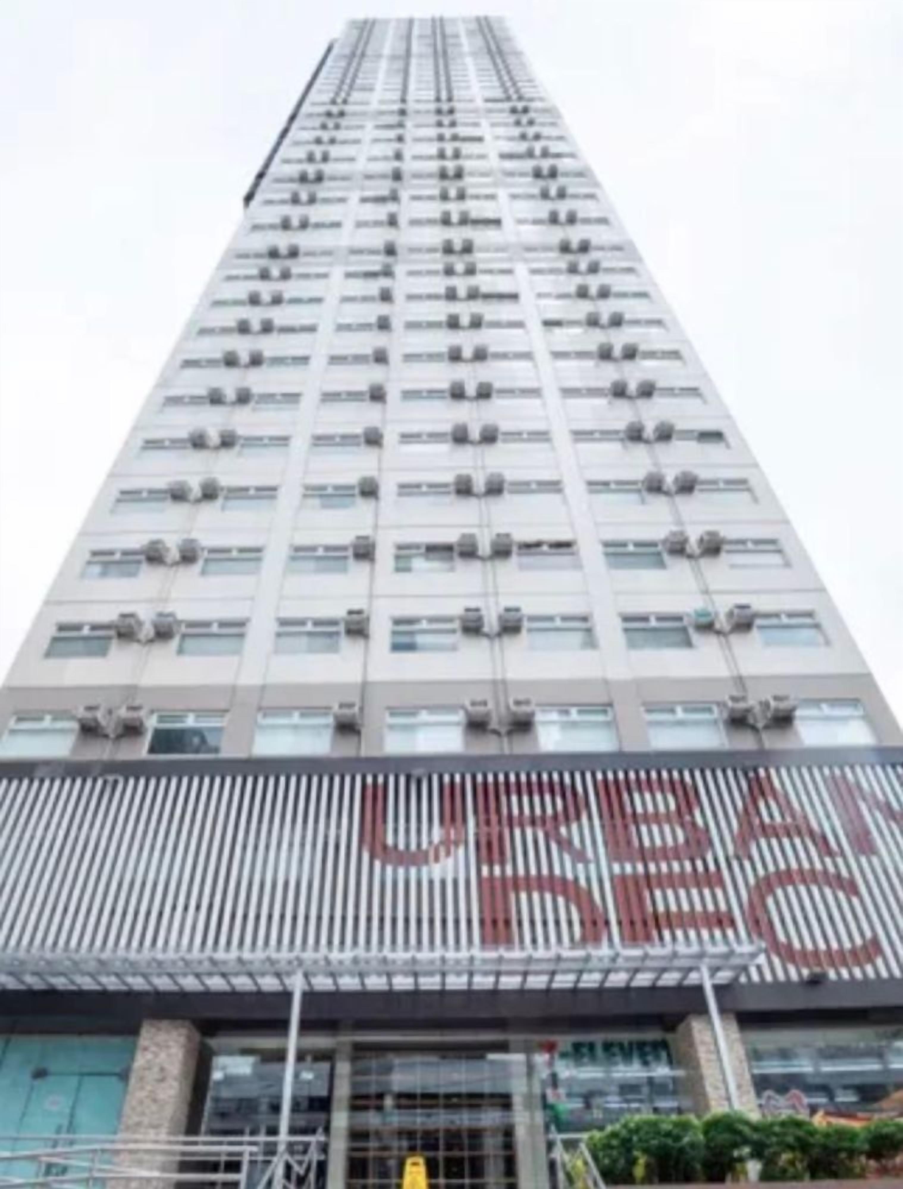 A tall building with a modern design, featuring multiple air conditioning units and a large sign with the word 'RESTAURANT' visible.