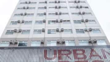 A tall building with a modern design, featuring multiple air conditioning units and a large sign with the word 'RESTAURANT' visible.
