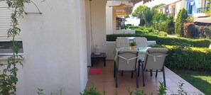An outdoor patio with a table and chairs, a small table with a lantern, and a red mat. - Sea View Paradise Retreat in Nikiti (Sithonia)