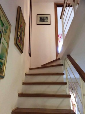 A staircase with wooden steps and a white wall. - Sea View Paradise Retreat in Nikiti (Sithonia)