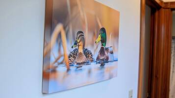 A painting of ducks on a wall.