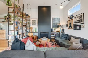 A modern living room with a fireplace, bookshelves, and artwork.