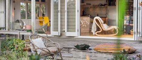 A cozy outdoor seating area with a fire pit, wicker chairs, and a dining table.