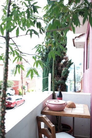 A balcony with a table, a chair, a bottle, and a bowl. - Bright apartment with a small pool, just 15 minutes from downtown Oaxaca. (Oaxaca de Juárez)