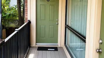 A green door with the number 6, a black metal railing, and a glass door to the right.