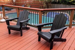 Two Adirondack chairs on a wooden deck with a pool in the background. - Casa Vista  Designer Home Pool Sleeps 16 (San Antonio)
