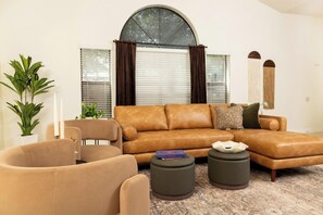 Ein Wohnzimmer mit Ecksofa, Couchtisch und Beistelltisch.