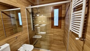 Un baño moderno con ducha envuelta en vidrio, inodoro y lavabo.