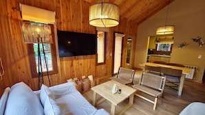 Un interior de madera con un sofá, una mesa y una televisión.