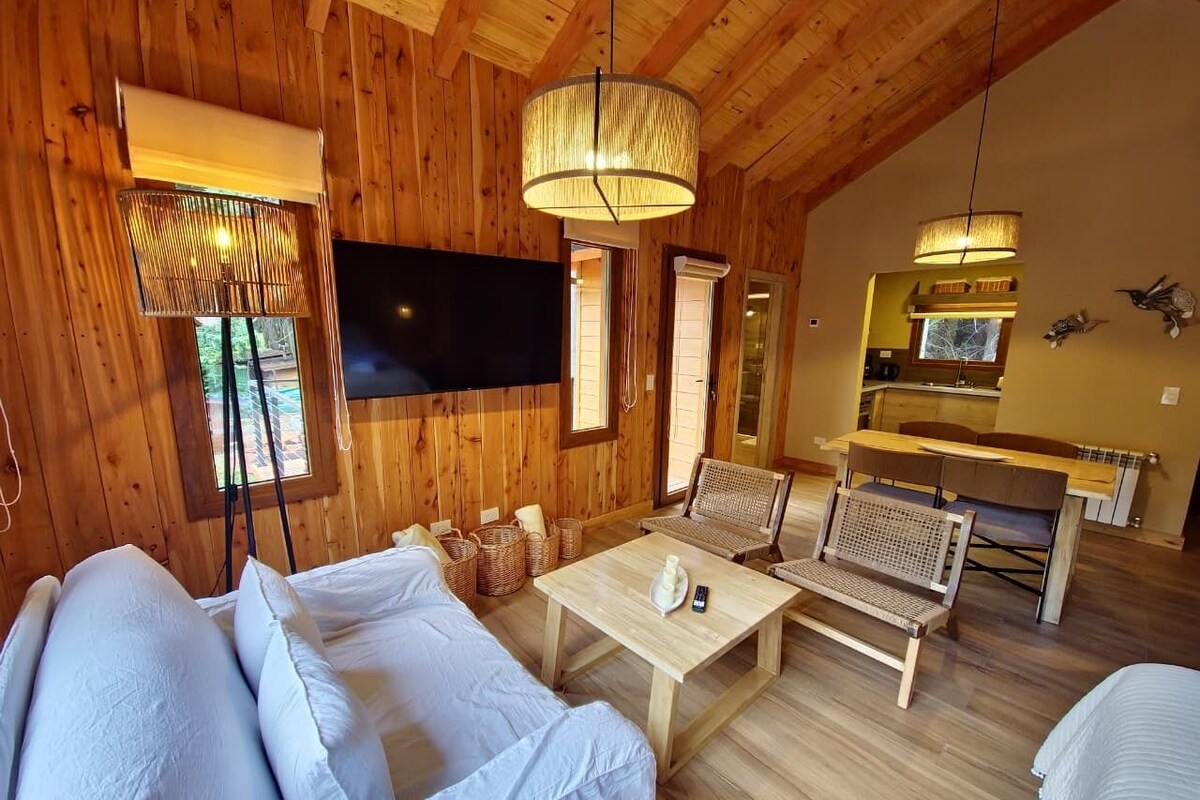 Ein Holzinterieur mit einer Couch, einem Tisch und einem Fernseher.