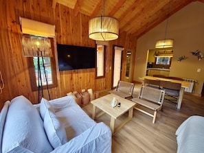 Ein Holzinterieur mit einer Couch, einem Tisch und einem Fernseher.