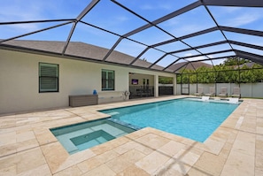 Ein Schwimmbecken mit freiem Blick zum Himmel, umgeben von einer überdachten Terrasse mit Stühlen und einer kleinen Sitzecke.