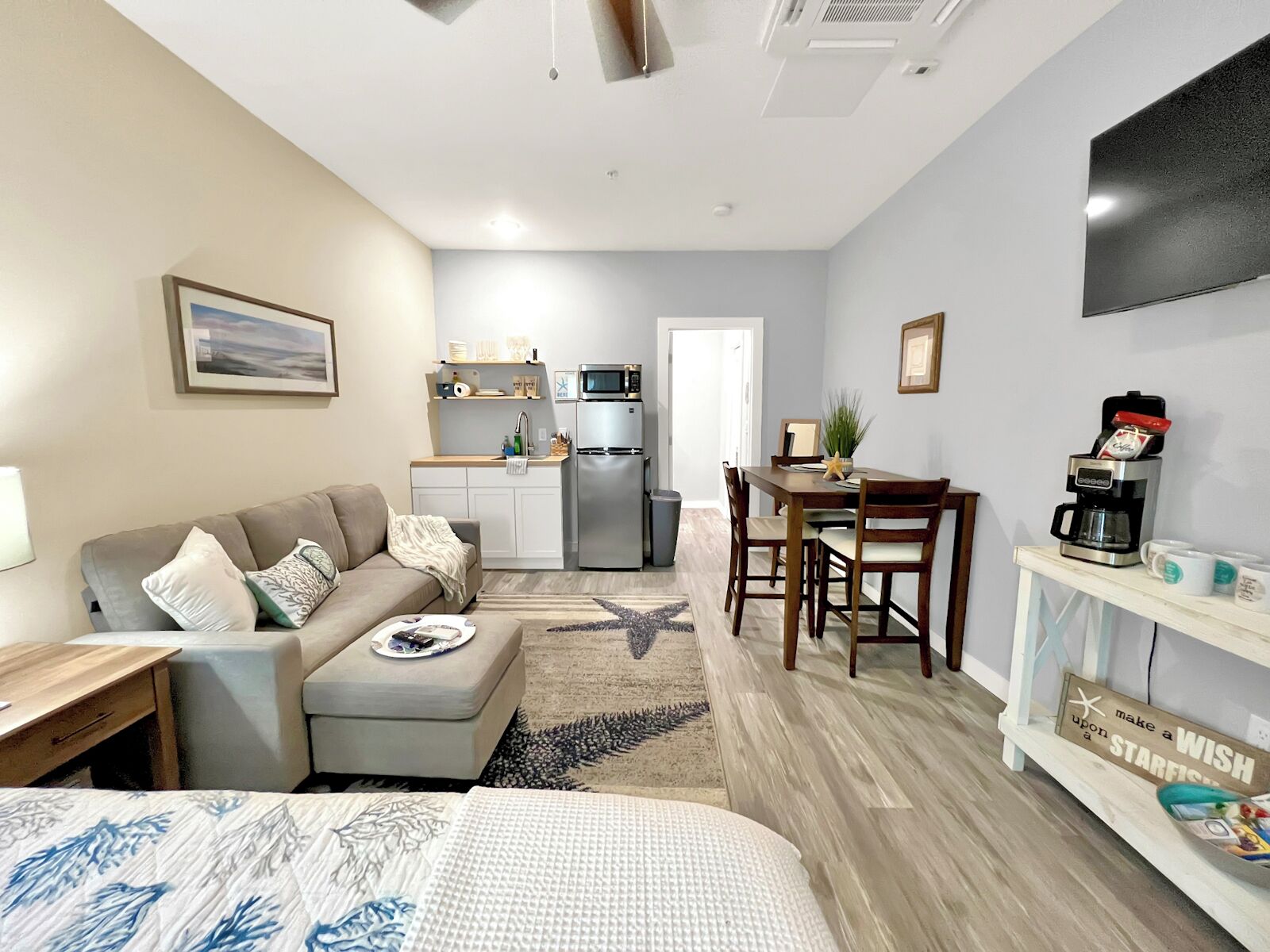 A compact living space with a kitchenette, a dining area, and a bed.