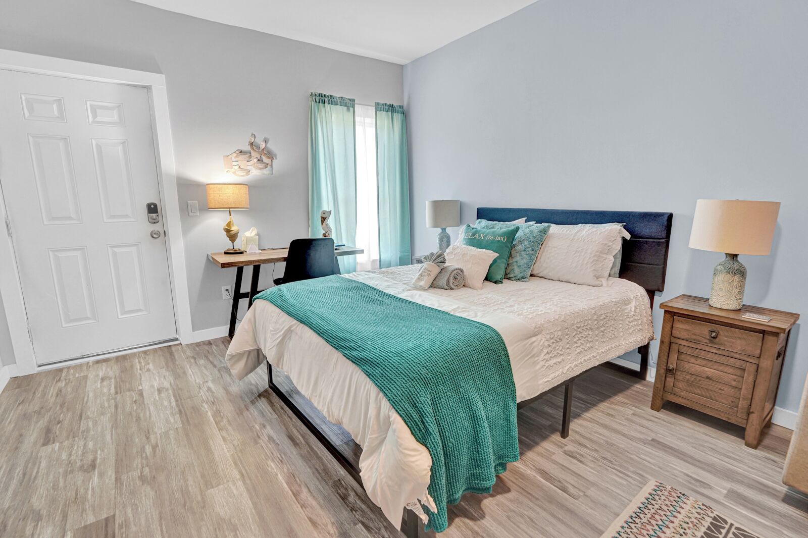 Une chambre à coucher avec un lit, des tables de chevet, un bureau et une chaise.