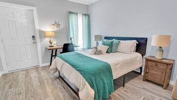 Une chambre à coucher avec un lit, des tables de chevet, un bureau et une chaise.