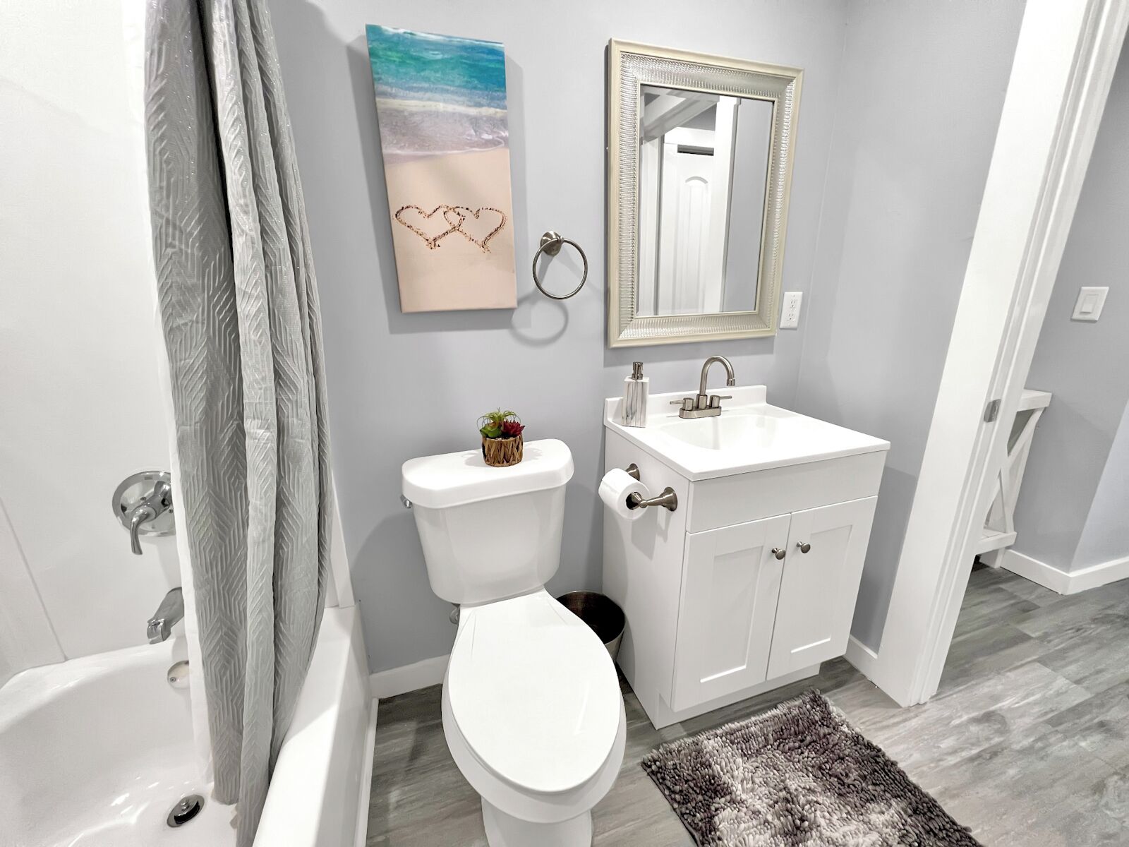 A bathroom with a toilet, sink, and bathtub.