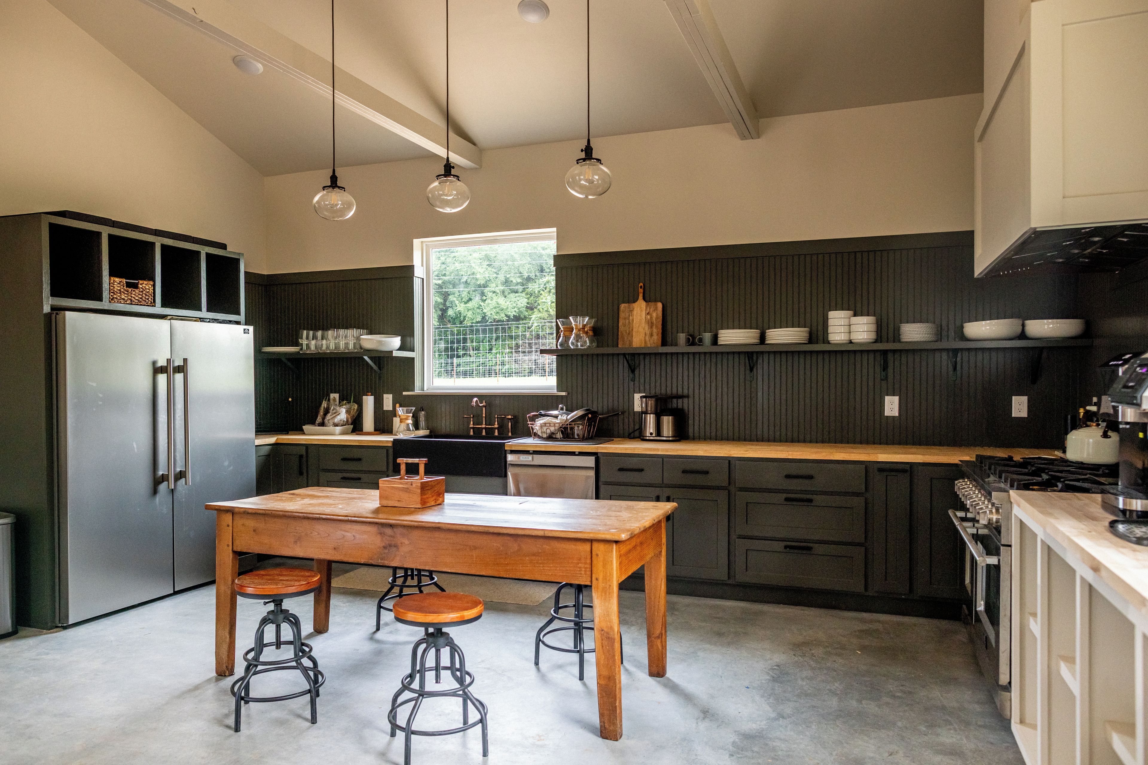 A modern kitchen with a central island, bar stools, and a window providing natural light.