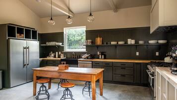A modern kitchen with a central island, bar stools, and a window providing natural light.