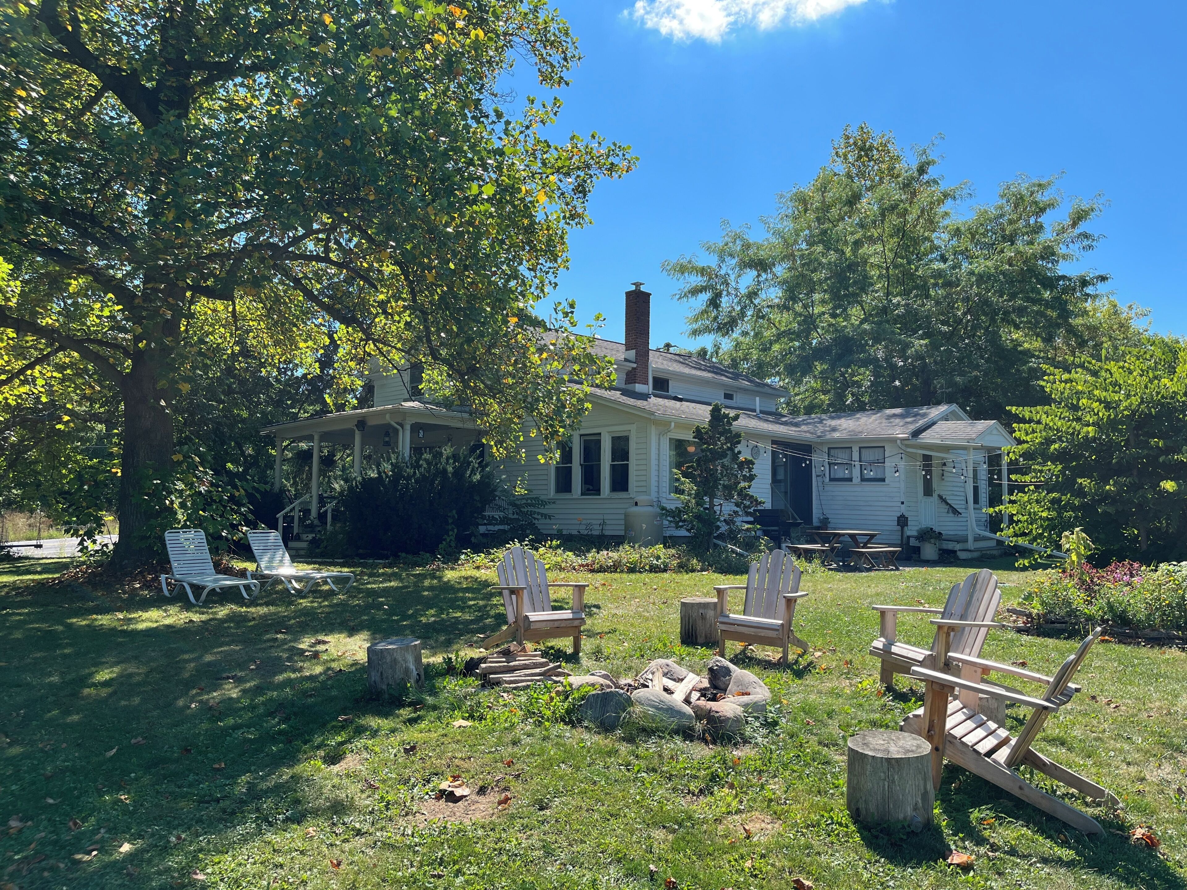 A house with a porch, outdoor seating, and a fire pit.