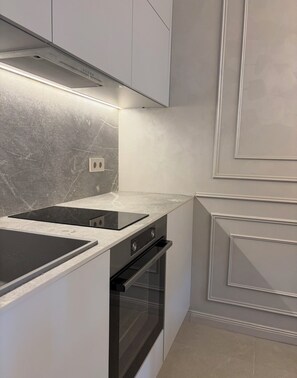 A modern kitchen with a built-in stove, oven, and a sleek countertop. - Stylish beach apartment near Kavatsi Beach, Sozopol (Sozopol)