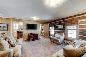 A log cabin interior with a living room, a television, and a fireplace. - Fisher Haul Historic Lodge | Hot Tub & Riverfront (South Fork)