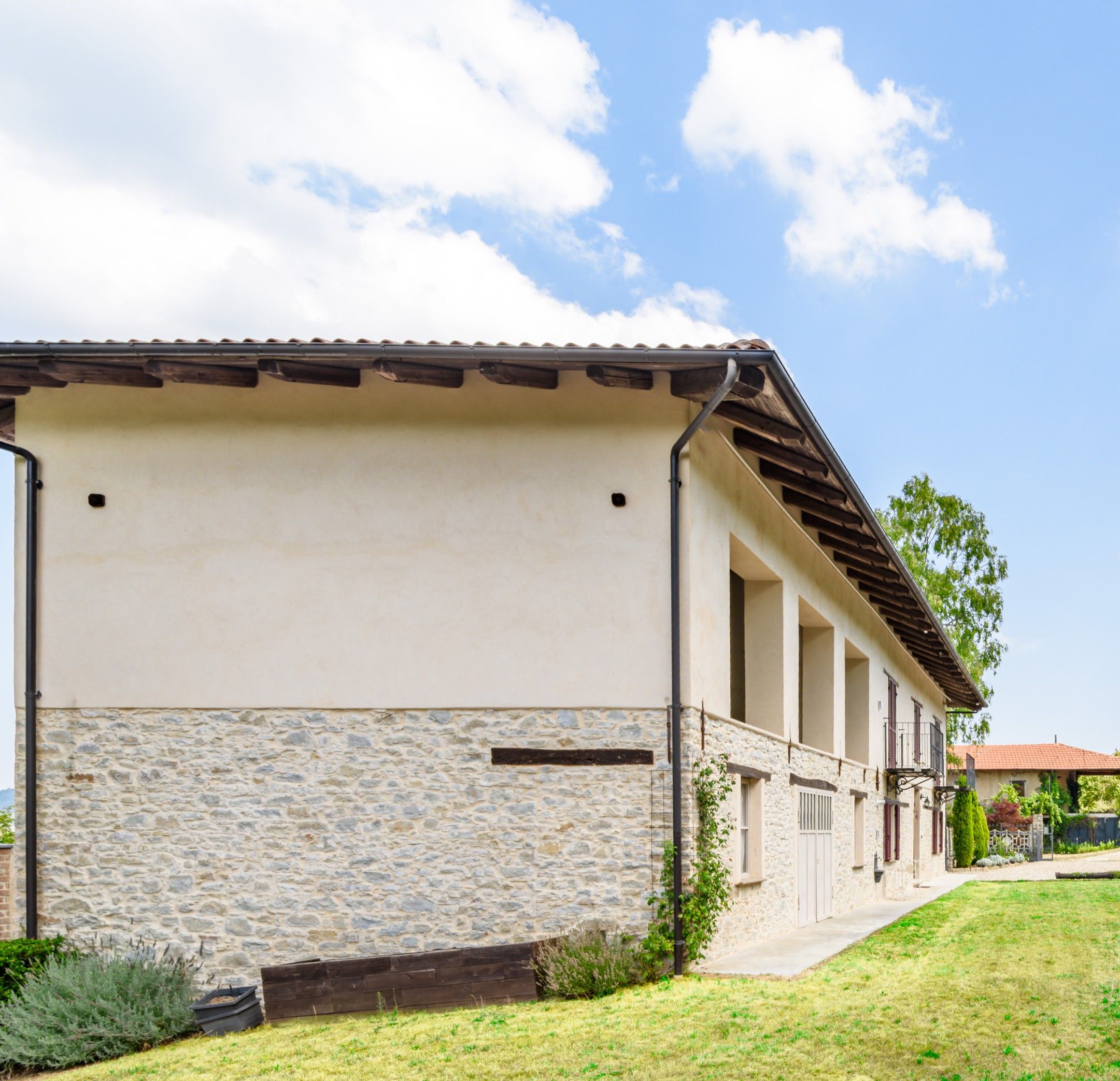 A building with a stone facade, a flat roof, and a covered walkway.