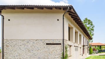 A building with a stone facade, a flat roof, and a covered walkway.