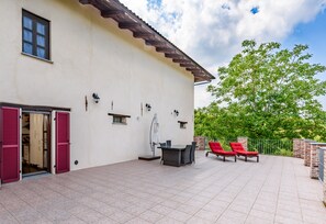 Una casa con patio, una mesa de comedor y sillas reclinables rojas.