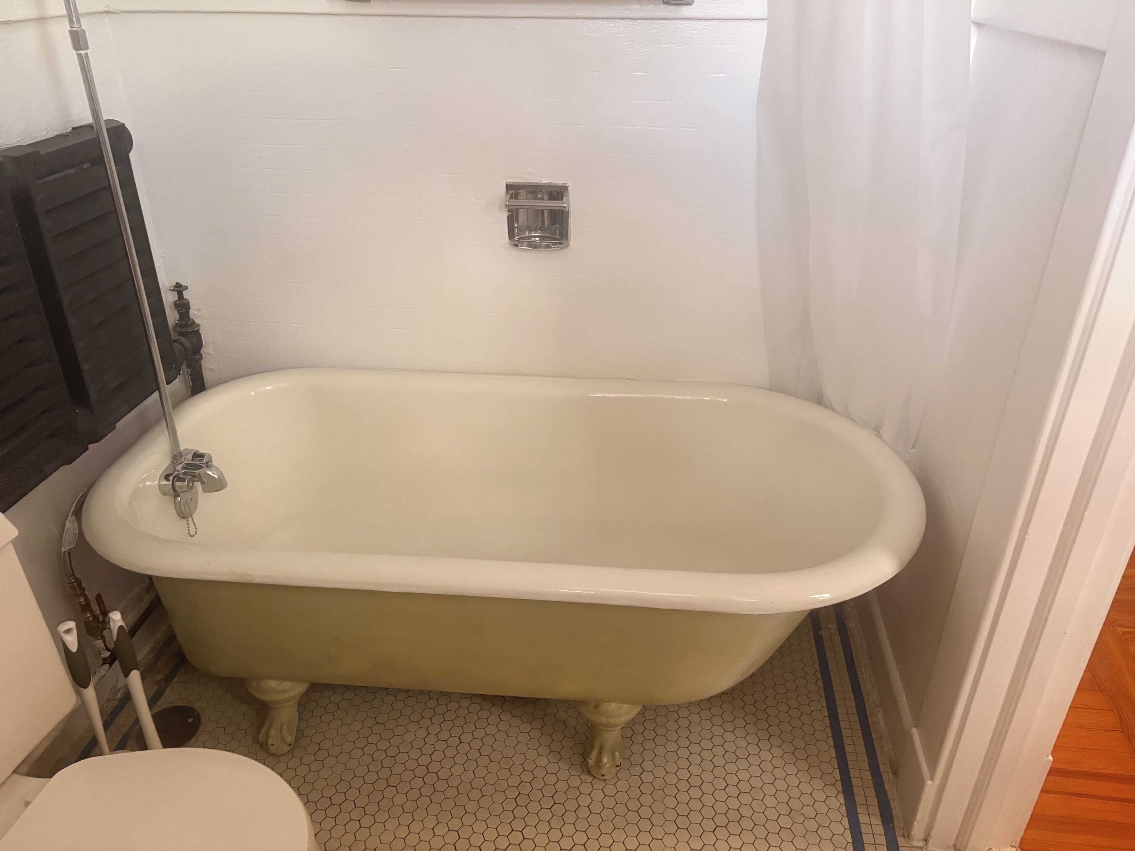 A bathroom with a freestanding bathtub, a toilet, and a shower area.
