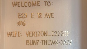 A wall with embossed text indicating a welcome message, address, and WiFi details. - Quiet central studio apartment in the Capital Hill neighborhood of Denver (Denver)