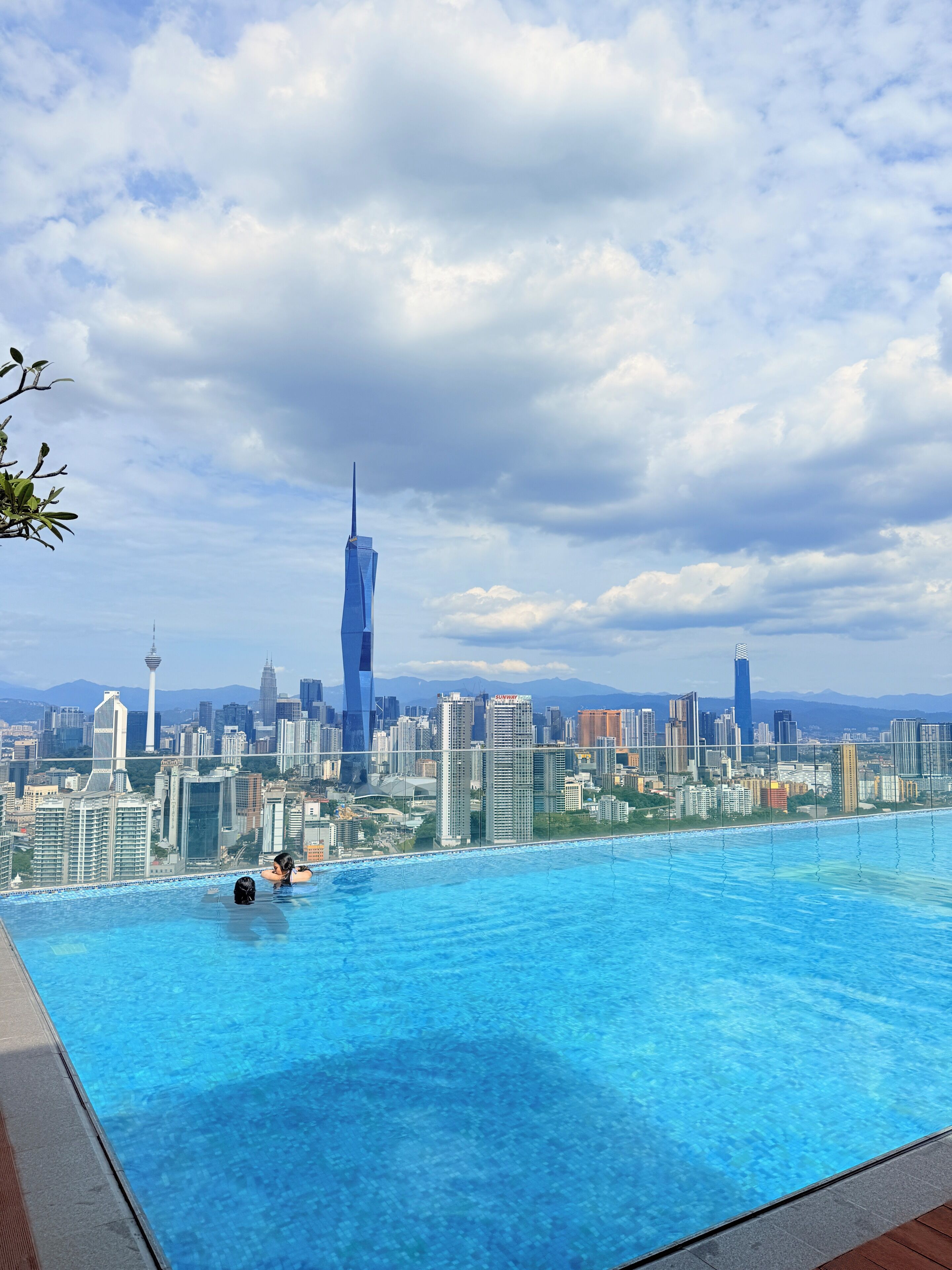 A rooftop infinity pool with a city skyline view, including a distinctive skyscraper.