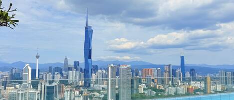 A rooftop infinity pool with a city skyline view, including a distinctive skyscraper.