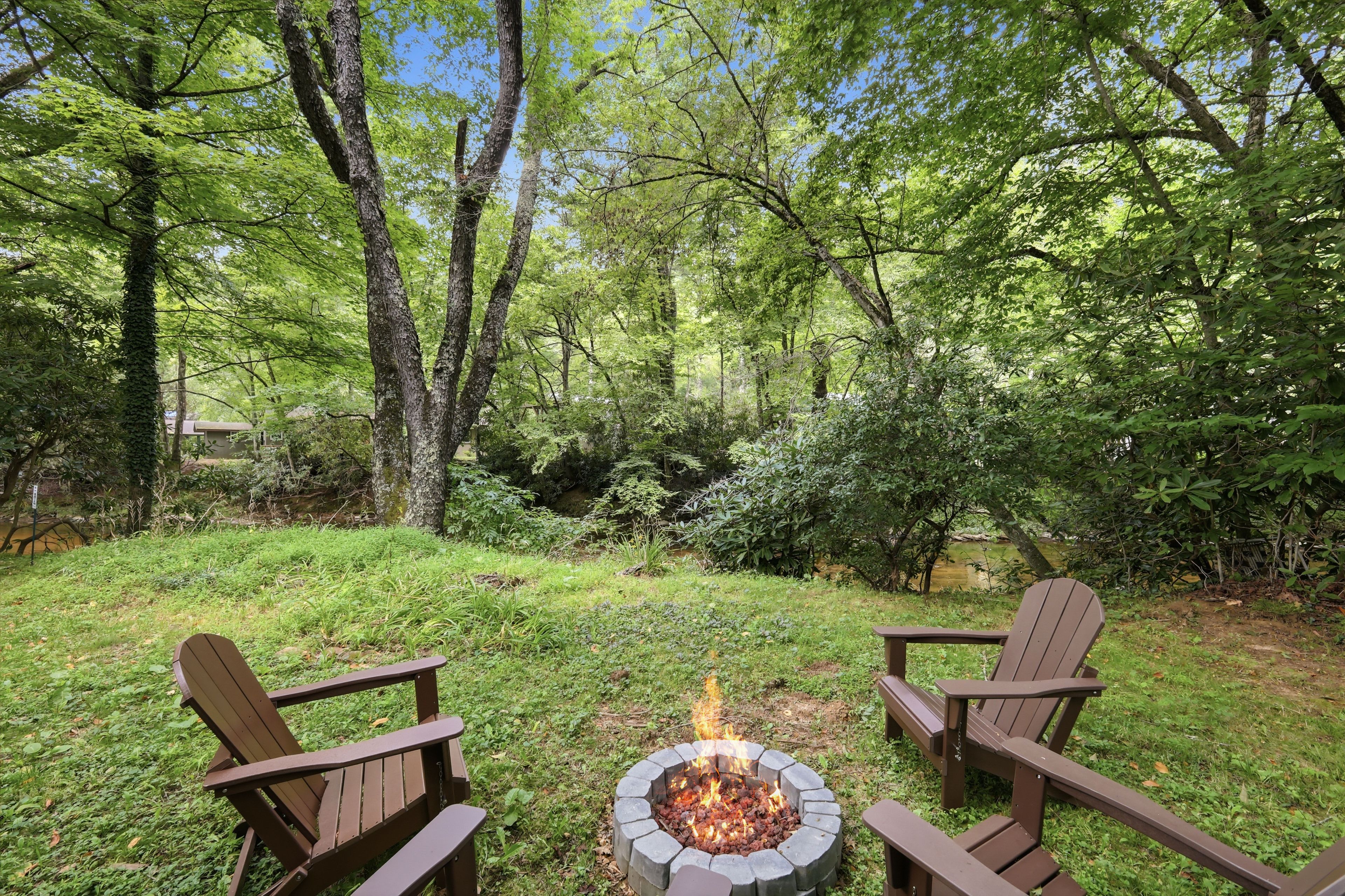 Un jardin avec un foyer et deux fauteuils Adirondack.