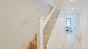 A staircase with white railings and wooden steps leading to a room with a bed and a window. - Broadstairs Duplex With Terrace Near Stone Bay FT1 (Broadstairs)