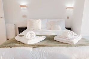 Une chambre d’hôtel avec un lit bien fait, deux tables de chevet et un radiateur.