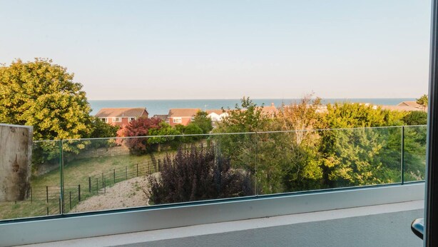 Un balcone con vista su una zona residenziale e il mare.